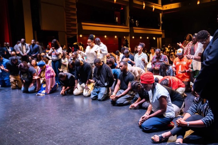 Kneeling together in prayer at a Dominion City gathering